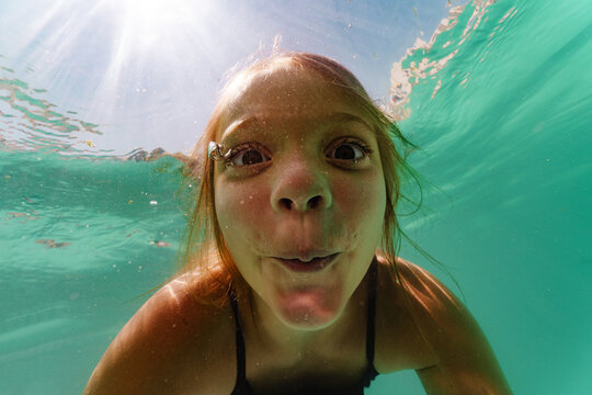 A happy girl dives into the swimming pool. Happy feeling on vacation concept.