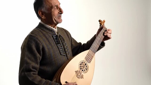 Elderly Man Playing Traditional Oud Instrument in Studio Portrait.