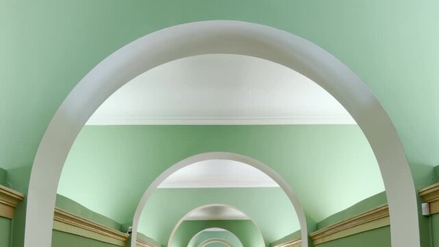 Graceful green arches frame a quiet hallway inside the historic Lyceum in Pushkin, Saint Petersburg. The symmetrical design inspires a peaceful feeling of calm wonder