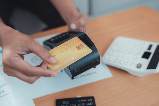 Contactless payment terminal card transaction financial advisor wealth planning at retail counter with calculator and receipt during secure banking service