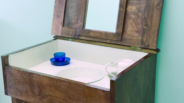 A wooden washstand holds a blue glass cup and pitcher inside a student room in Pushkin, Saint Petersburg. This simple historical setting evokes a peaceful and nostalgic feeling.