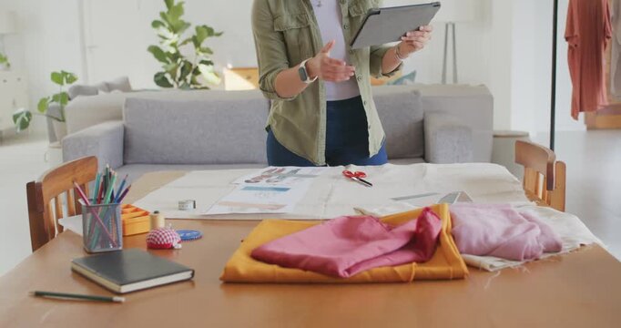 African American woman reaching ruler upon seeing pattern at home table measuring with tablet