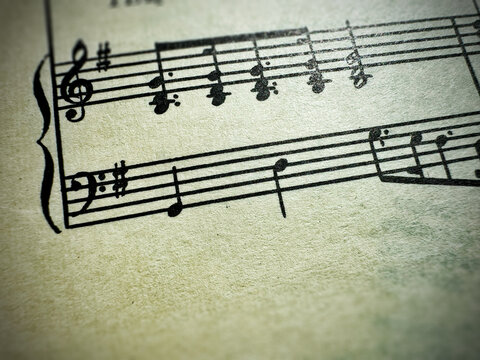 Close up of sheet music notes and textured paper. Musical notes on sheet music with clear details. Image of a sheet of music with notes. For scrapbooking collage, journal design, and craft projects.