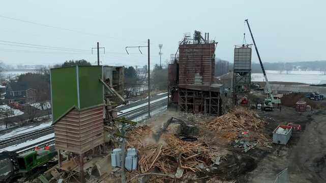 Gordonville, Pennsylvania, United States - 19 February 2026: Aerial view of an industrial demolition site with a crane, excavator, and debris near railway tracks.