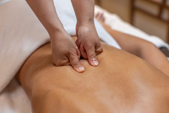 Close Up of Therapist Using Thumbs for Deep Tissue Back Massage on Female Client