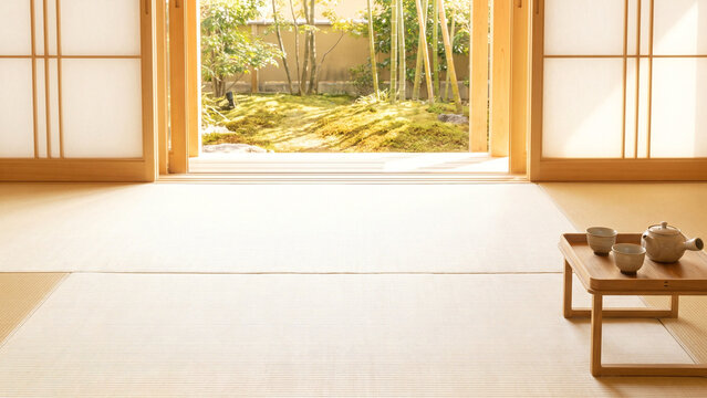 暖色の自然光が差す広い畳の和室で竹と苔の坪庭を望み右下に木製茶台と茶器を置いた障子の室内