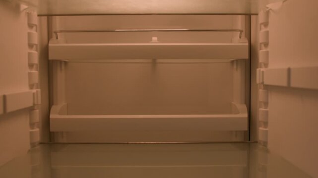 Hungry Caucasian man opening empty fridge shelves in kitchen sad disappointed male bachelor needing food delivery groceries unemployed guy budget crisis searching meal POV inside refrigerator home