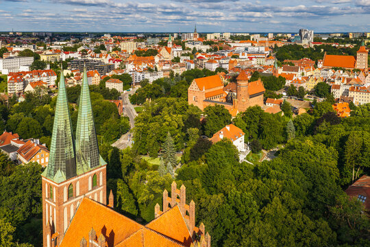 Aerial view of the Cathedral of St. James and the medieval Castle of the Warmian Chapter surrounded by lush green trees in Olsztyn, Warmian-Masurian Voivodeship, Poland.