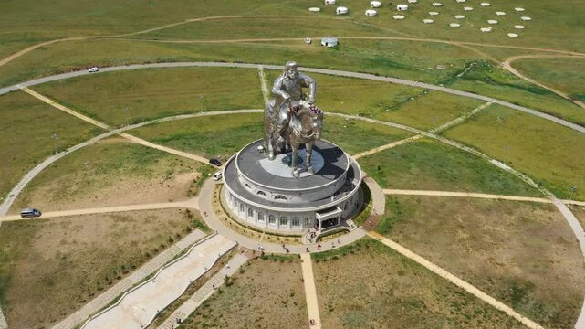 Nalaikh, Ulaanbaatar, Mongolia - 22 August 2019: Aerial view of the massive stainless steel Chinggis Khaan Statue on a circular base in the steppe with traditional gers in the distance.