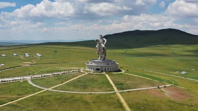 Nalaikh, Mongolia - 21 August 2019: Aerial view of the Chinggis Khaan Statue standing on the vast green steppe with traditional gers in the distance.