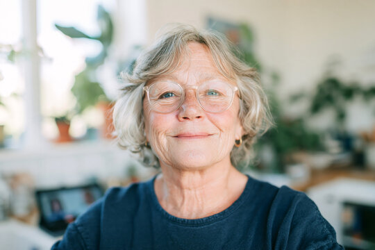 Smiling Senior Woman with Short Gray Hair at Home in Bright Living Room