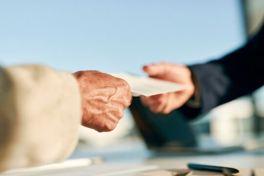 Business Handshake Over Contract Documents at Office Table in Warm Backlight