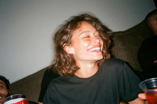 Two Friends Laughing Together at Indoor Party with Flash Photography Aesthetic