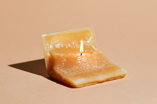 Melting  Candle Shaped Like Laptop on Red Surface in Surreal Food Still Life