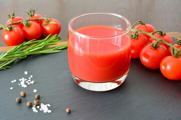 a glass of Tomato Juice with Cherry Tomatoes and Herbs on Slate Surface © Irina