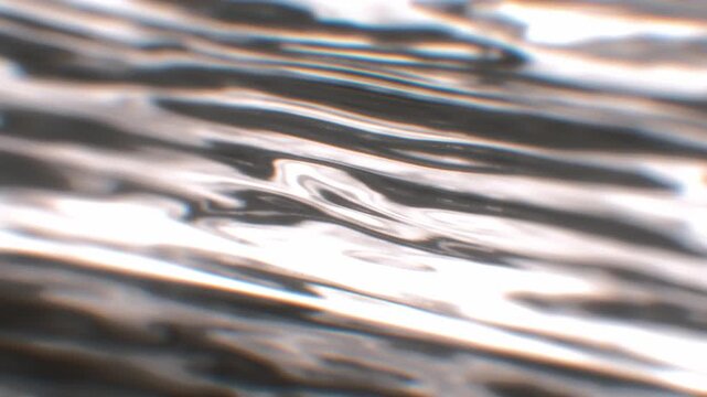 Abstract silver metallic fluid waves ripple horizontally with chrome reflections in a high tech 3D motion background