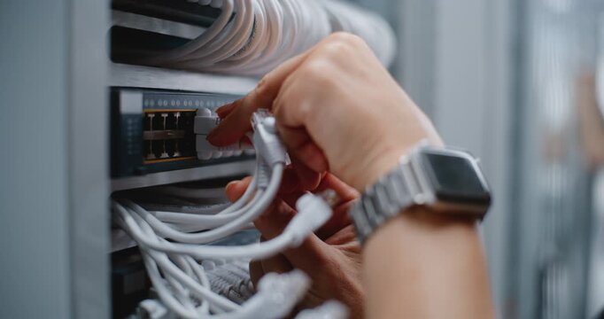 Close Up of Engineer Inspects Server Rack Cabling and Adjusts Ethernet Connections, Using Cable Management to Maintain Clean Routing, Proper Bend Radius and Reliable Infrastructure Within Data Center.