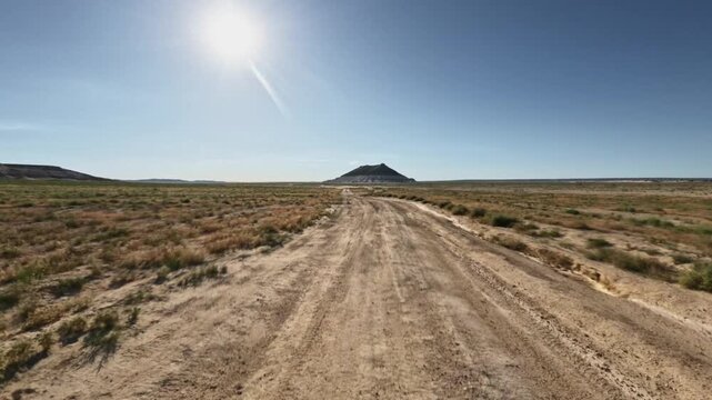 Forward movement along dirt road toward distant hill