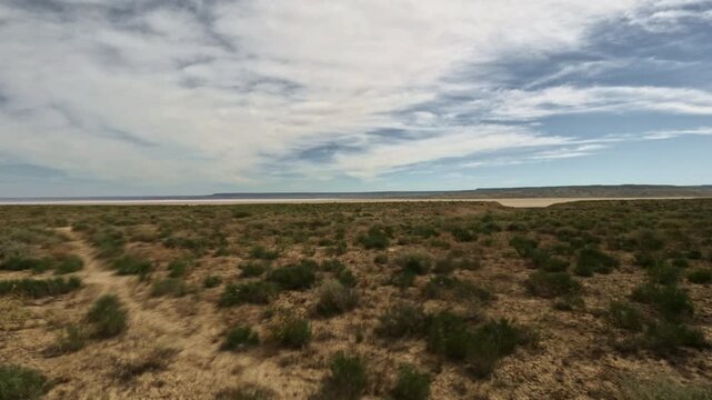 Low angle forward tracking shot over arid landscape