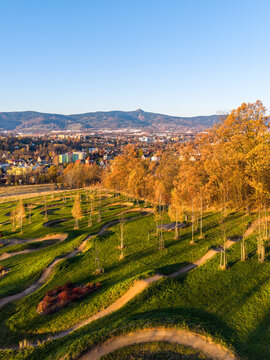 Aerial view of VAPARK with winding dirt tracks, autumn trees, and green hills overlooking the city of Liberec, Liberec Region, Czechia.