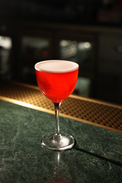 Red Alcoholic Sour Cocktail with Foam in Stemmed Glass Close Up