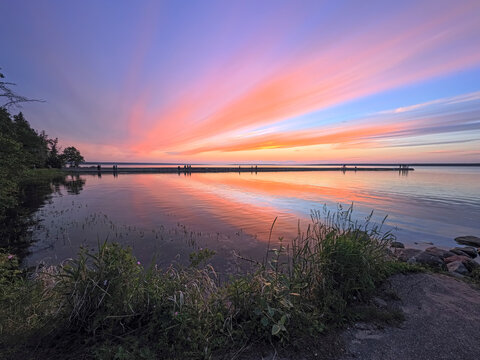 Vibrant Pink and Orange Sunset Reflected Over a Calm Waskesiu Lake in Prince Albert National Park, Canada