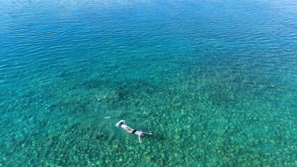 A man in a mask and flippers is swimming in clear, transparent water at the sea © Павел Чигирь