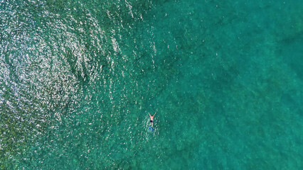A man in a mask and flippers is swimming in clear, transparent water at the sea © Павел Чигирь