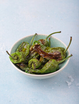 Padron peppers fried bowl sea salt light blue background appetizer Spanish