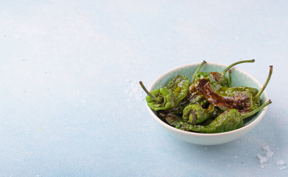 Padron peppers fried bowl sea salt light blue background appetizer Spanish copy space