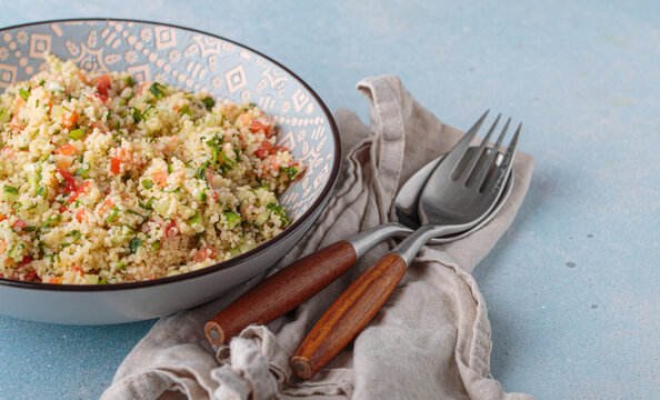 Tabbouleh salad couscous vegetables bowl Middle Eastern blue background