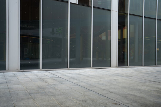Modern building glass curtain wall and gray paved ground