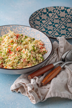 Tabbouleh salad couscous vegetables bowl Middle Eastern blue background