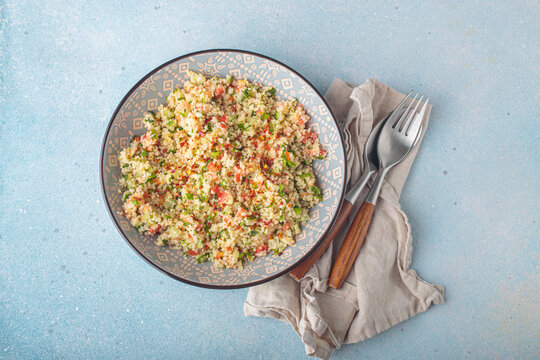 Tabbouleh salad couscous vegetables bowl Middle Eastern blue background top view