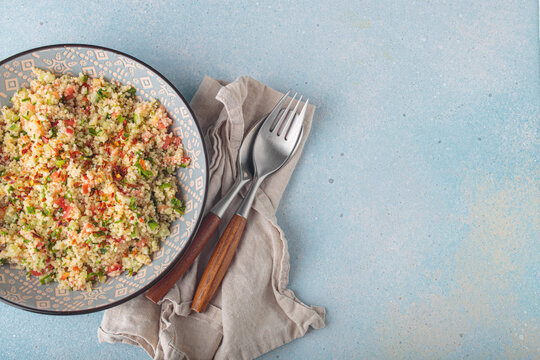 Tabbouleh salad couscous vegetables bowl Middle Eastern blue background top view copy space