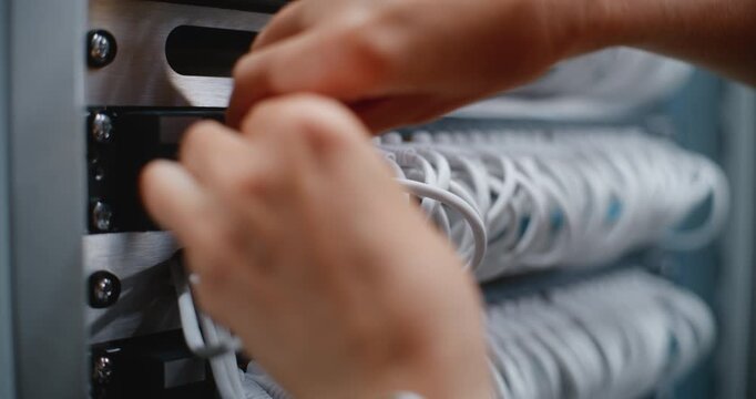 Close Up of Female Technician Works on Network Switch Ports and Patch Cables in Server Cabinet, Performing Physical Layer Maintenance, Structured Cabling Organization For Enterprise Network Services.