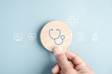 Medical healthcare and wellness prevention concept. Hand holding wooden block with stethoscope and...