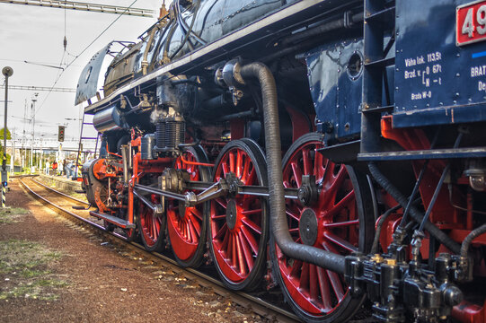 View of the Albatros 498 104 steam locomotive at the railway station, featuring large red wheels and complex mechanical linkages in Zvolen, Banskobystricky kraj, Slovakia.