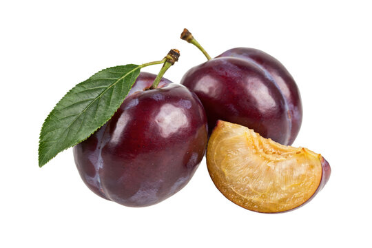 Two whole ripe purple plums with a green leaf and one sliced wedge showing yellow flesh isolated on a transparent background