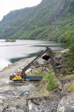 August 16, 2026, Saudasj&oslash;en, Norway - Volvo EC530E excavator with long reach arm on a construction site by a fjord