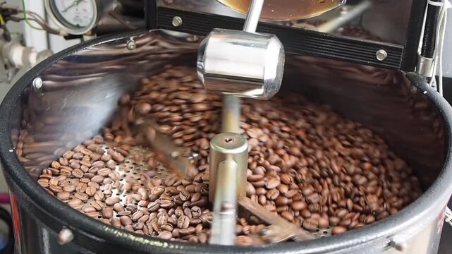 The cooling process of freshly roasted coffee beans, cooled using sucked air in the cooling tray of the coffee roasting machine