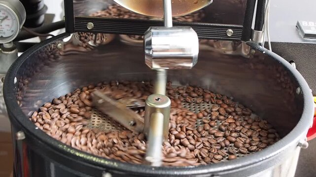 The cooling process of freshly roasted coffee beans, cooled using sucked air in the cooling tray of the coffee roasting machine