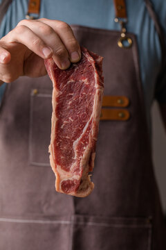 The chef is in the kitchen holding a steak. Prepared beef steak. Food and Drink Concept.