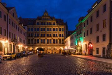 Fototapeta premium Stunning night cityscape of Görlitz, Germany. Beautifully illuminated historic Old Town, medieval architecture, and bright street lights highlighting the rich cultural heritage at dusk.