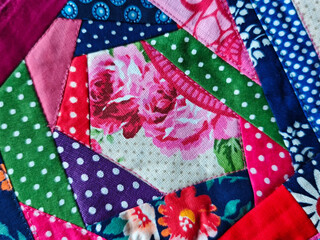 Colorful quilt patchwork design showing floral patterns and various textures in fabric pieces