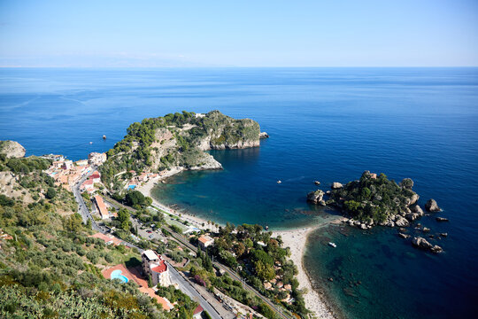 Aerial view of the stunning Isola Bella in Taormina, Sicily, showcasing its rocky shores, verdant vegetation, and crystal-clear turquoise waters