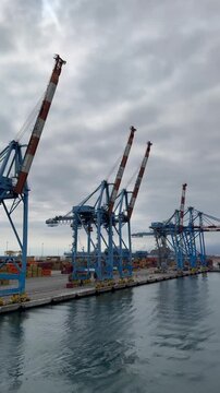 26 April 2026, Italy, Liguria, Genoa, Port Terminal Contenitori - vertical close up of seaport gantry PSA SECH STS cranes semi-circular beam for unloading and loading infrastructure