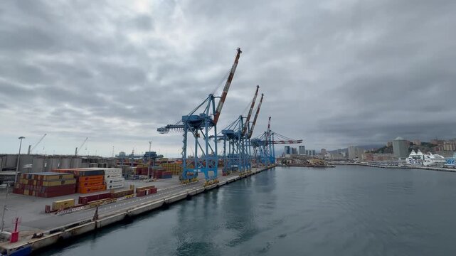 26 April 2026, Italy, Liguria, Genoa, Port Terminal Contenitori overlooking skyline - container zone and seaport gantry PSA SECH STS cranes semi-circular beam for unloading and loading infrastructure