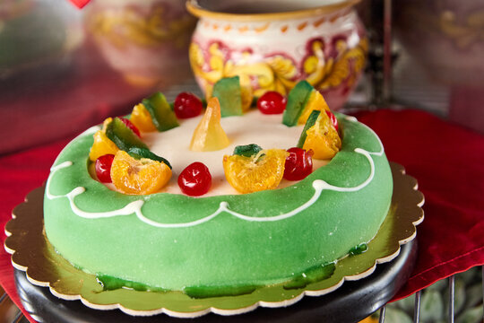 Cassata Siciliana is a traditional Sicilian cake made with ricotta, sugar, sponge cake, marzipan, candied fruit, and powdered sugar.