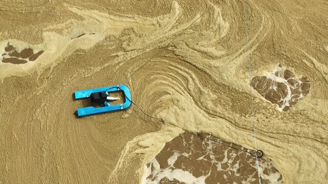 Drone perspective reveals industrial wastewater undergoing aeration treatment, representing oxygenation, water remediation, pollution reduction, and environmentally responsible industry.
